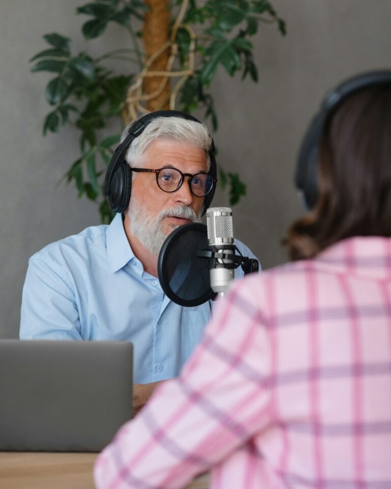 a man wearing headphones records his voice into a microphone in a recording studio