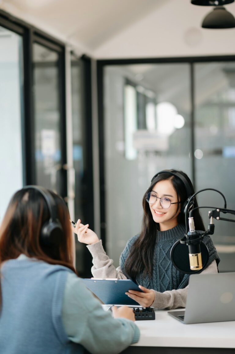 Asian woman wearing headphones and doing a live podcast for their channel, communication