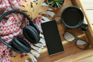 A phone with headphones for listening to audiobook, music or podcast - blank screen mock up